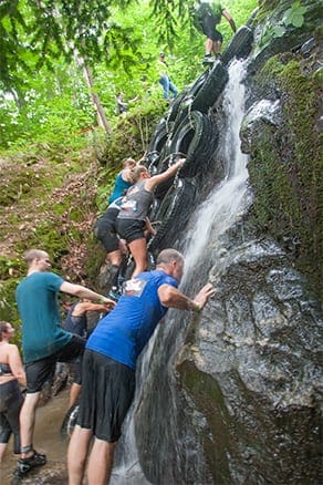 Competitor climbing up waterfall